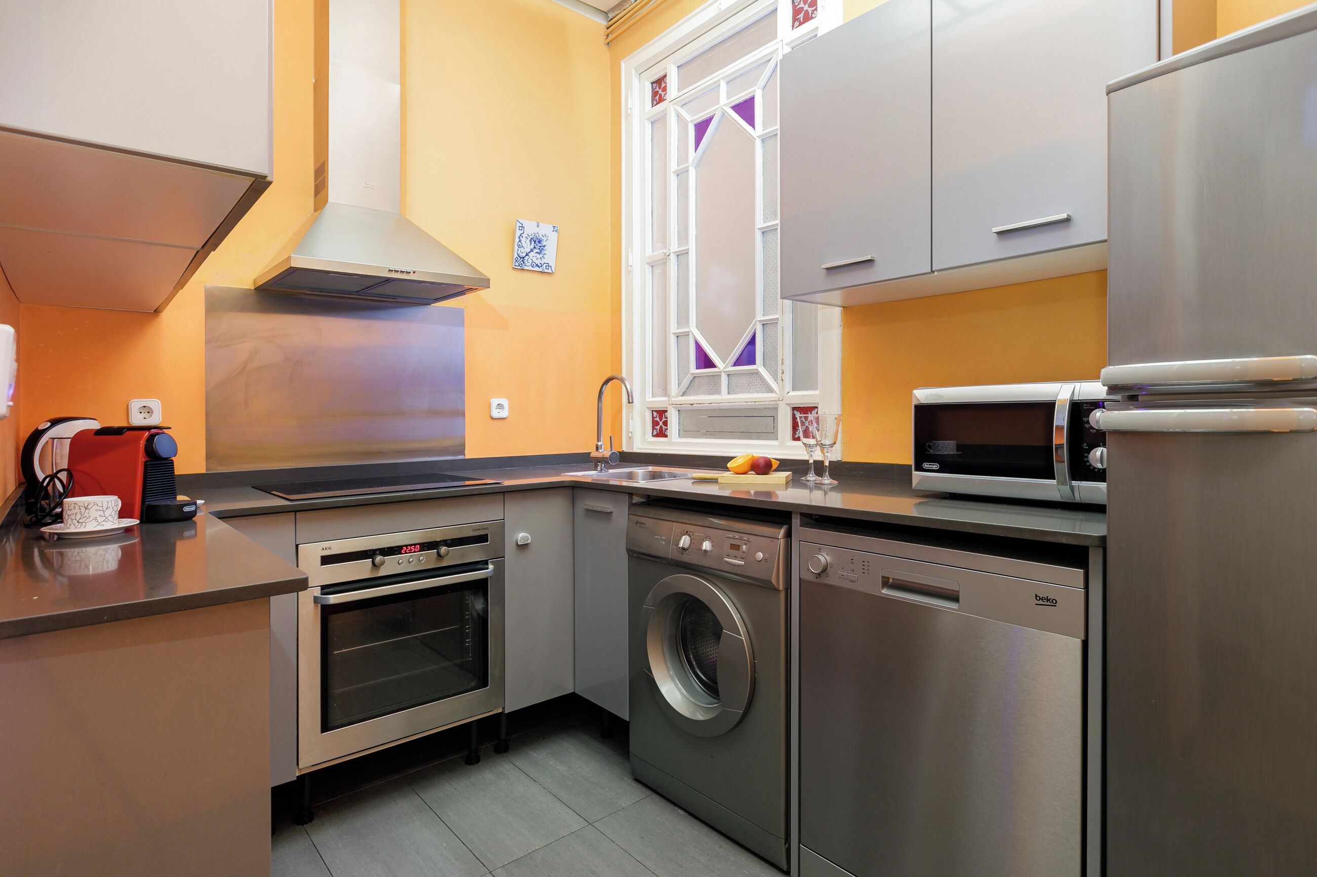 A modern kitchen with stainless steel appliances, including an oven, microwave, and dishwasher.