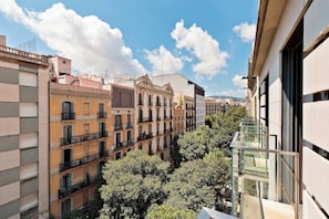A multi-story urban building with balconies and a glass railing. - Enjoy Apartments Maria (Barcelona)