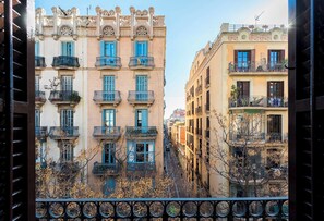 A row of buildings with balconies and windows, viewed from a balcony with a railing. - Enjoy Apartments La Riera One (Barcelona)