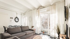 Egy modern nappali, szürke színű kanapéval, dohányasztallal és televíziós állvánnyal.
