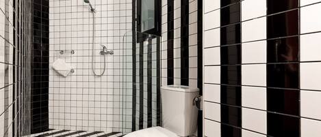 A bathroom with a black and white checkered floor, a white toilet, and a shower area with a glass enclosure.