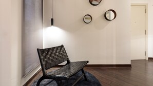 A hallway with a bench, three wall-mounted mirrors, and a door at the end. - Enjoy Apartments Urban Retreat Valencia (Barcelona)