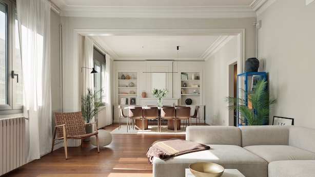 Una sala de estar moderna con un sofá, una mesa de centro y un comedor con sillas y una mesa.