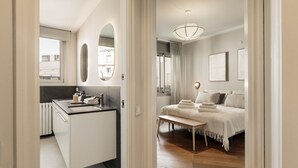 Un dormitorio moderno con cama, mesita de noche y vistas a la ciudad.