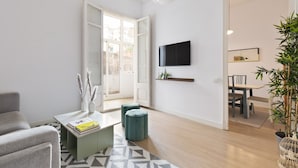 Een moderne woonkamer met een bank, salontafel en een televisie aan de muur.
