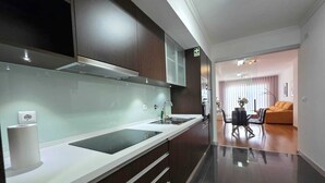 Et moderne køkken med stilrent design, indbygget ovn og stort vindue.