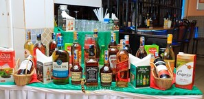 A variety of liquor bottles and boxes on a table at a hotel bar. - Legacy Star Hotel Chuka (Chuka)