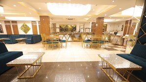 Un hall espacioso con una zona de bar central, diferentes disposiciones de asientos y un suelo de mármol pulido.