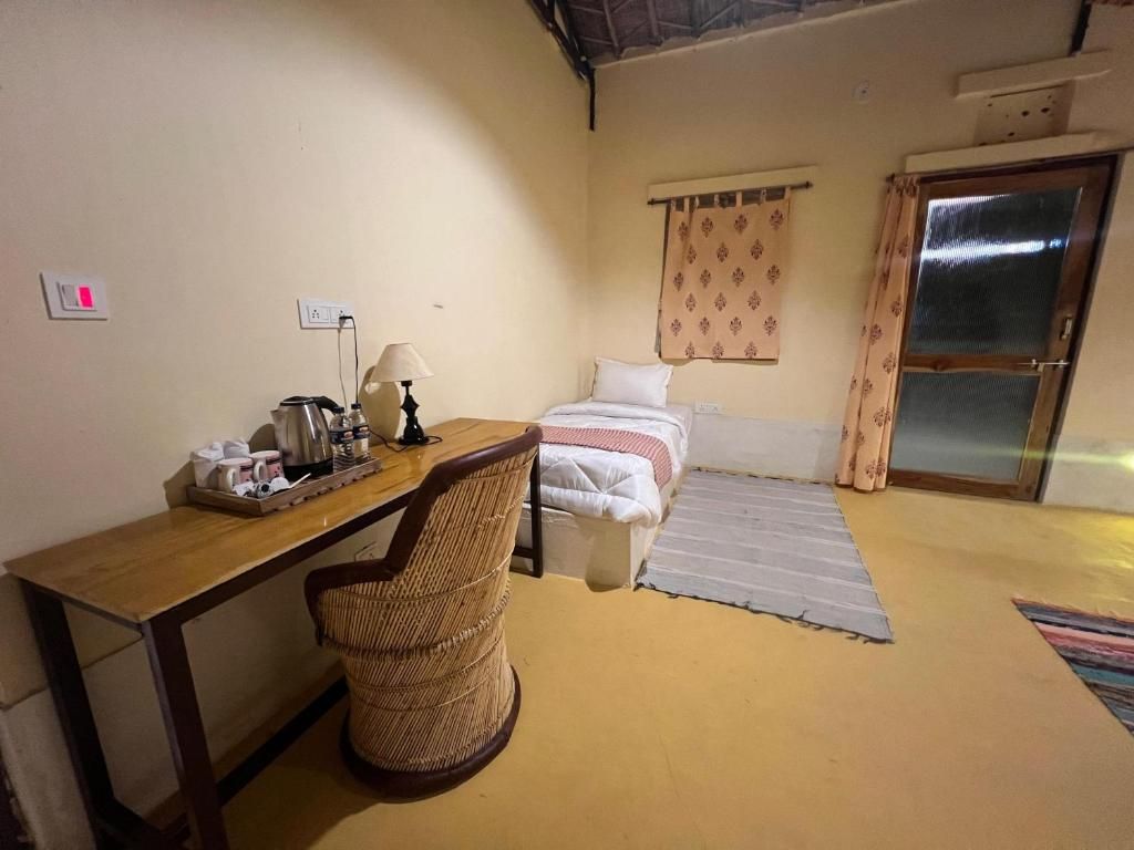 A room with a bed, a desk, a chair, a window with curtains, and a door.