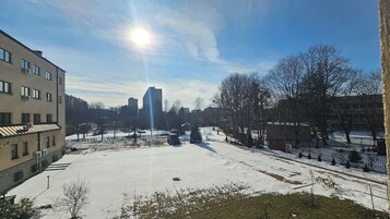 A snowy courtyard with buildings, a van, and a clear sky.