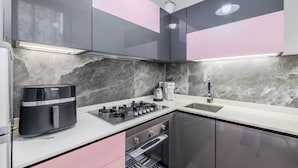 Een moderne keuken met een gasfornuis, koffiezetapparaat en roestvrijstalen apparatuur.