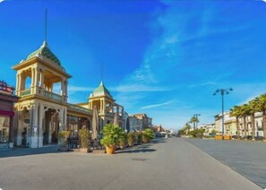 A street with a prominent building featuring a green dome and a balcony. - Just steps from the beach (Viareggio)