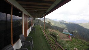 Un balcon fermé offrant une vue sur un paysage montagneux.