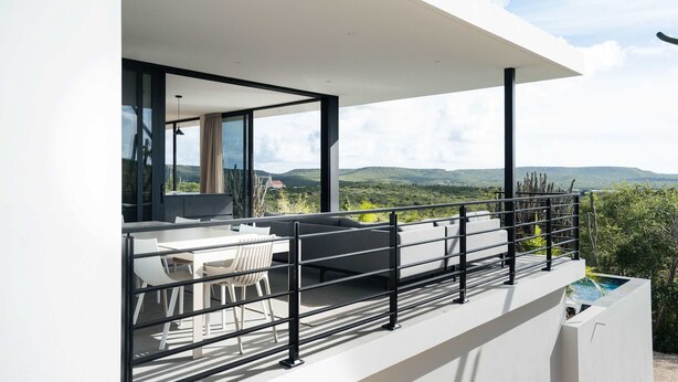 Ein moderner Balkon mit Essbereich, einer Sitzecke und einem Pool.