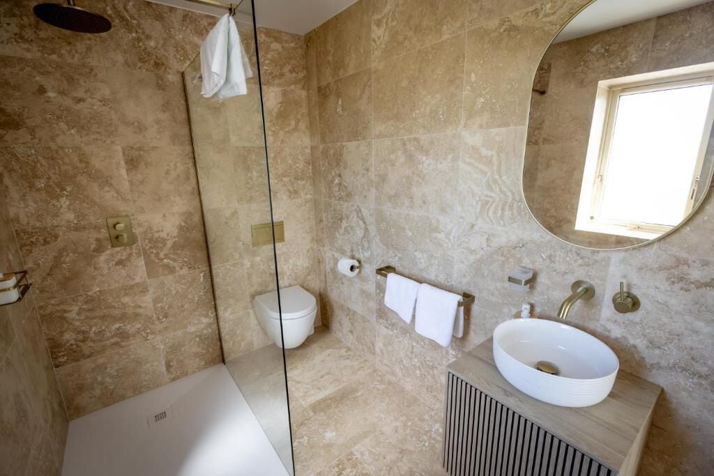 Un baño moderno con bañera, lavamanos e inodoro.