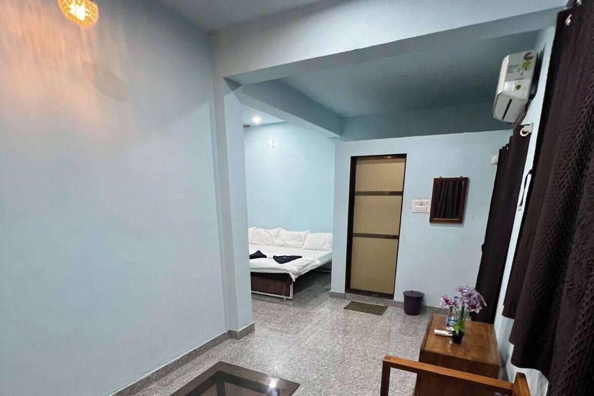 Egy praktikus, kisebb méretű lakótér, melyben található egy kanapé, egy üveglapos dohányasztal, egy kis, fából készült dobozasztal, egy ágy és egy tolóajtó.