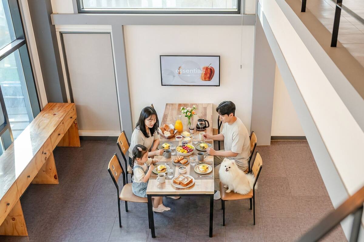 A dining area with a wooden table, chairs, and a framed picture on the wall.