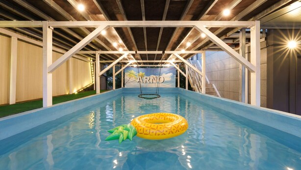 An indoor swimming pool with a clear view of the ceiling structure, a swing, and a banner with the word "ARNO". - Gyeongju Bomun Arno Pool Villa (Gyeongju)