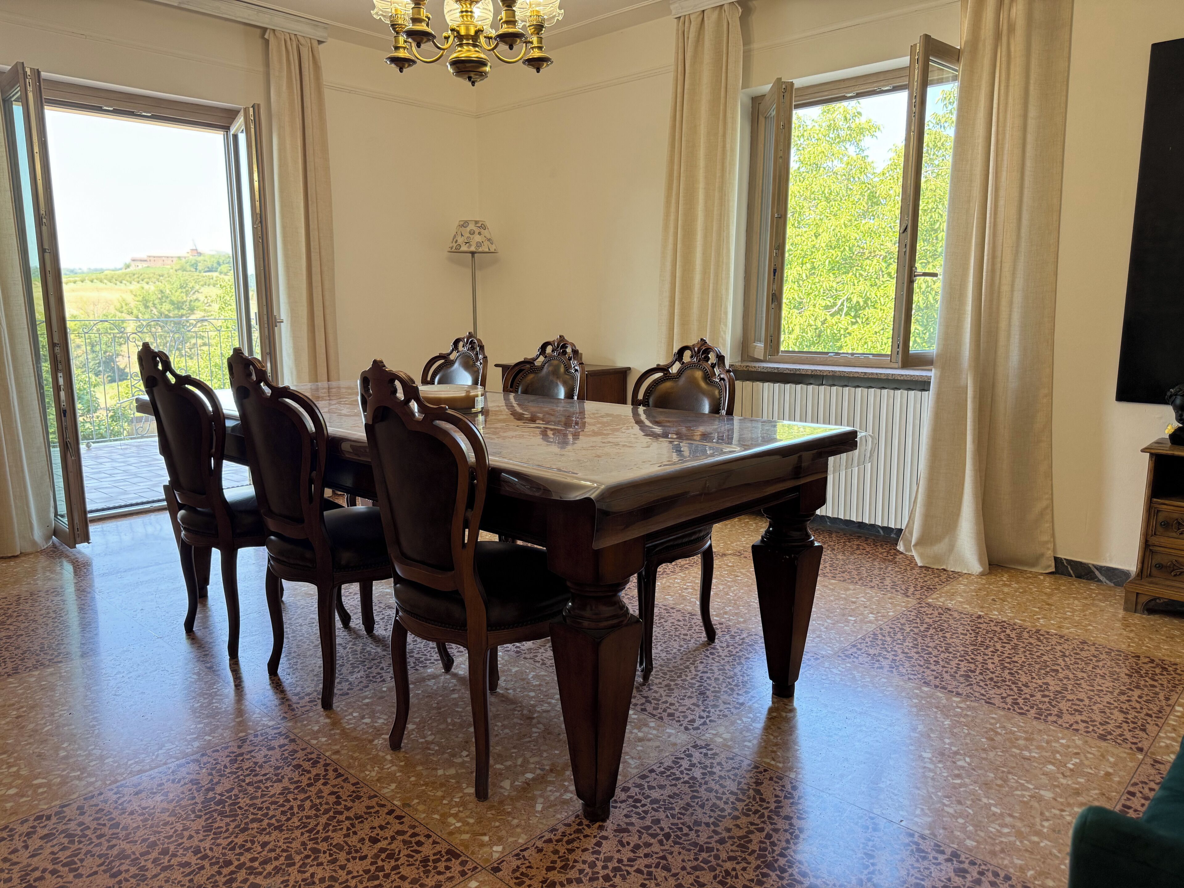 Ein Esszimmer mit einem großen Tisch, Stühlen und einer Chandeliebre.