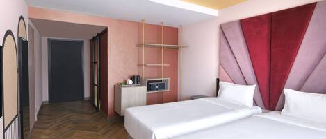 Habitación de hotel con dos camas, un escritorio pequeño con microondas y un armario con espejo.