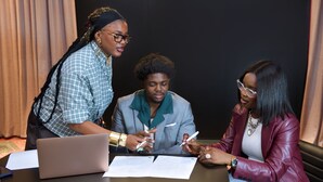 Three people at a table with documents, a laptop, and a pen. - Ibis Styles Kinshasa (Kinshasa)