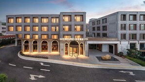 A modern hotel with a central entrance, multiple floors, and a well-lit facade. - Mercure Hangzhou West Lake Yuquan (Hangzhou)