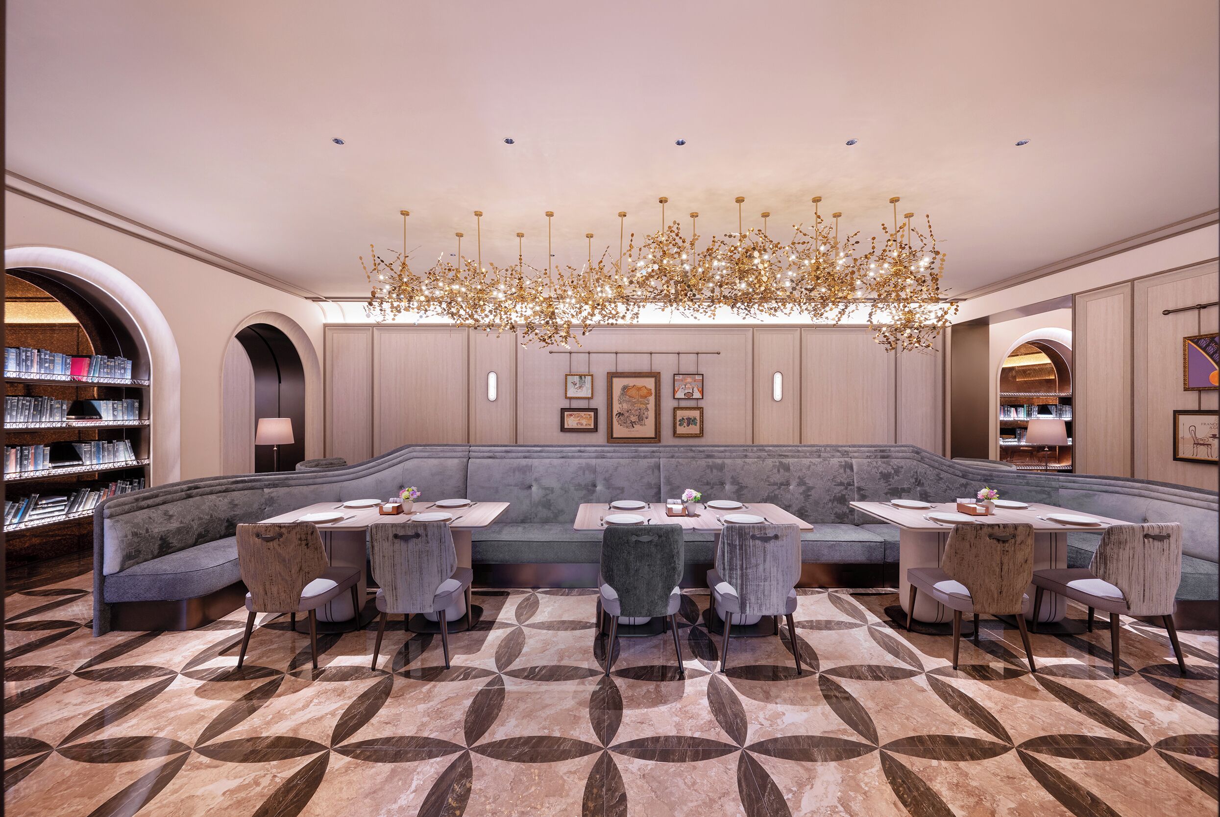 A modern interior with a seating area, a chandelier, and a patterned floor.