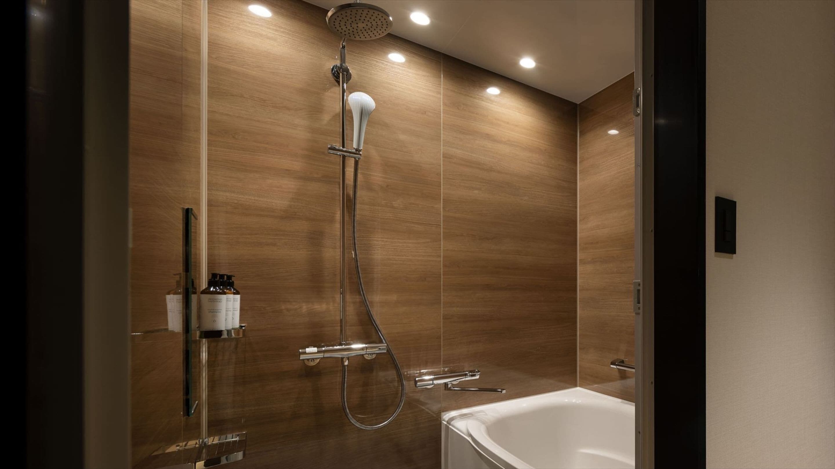 Une salle de bain moderne équipée d’une douche, d’une baignoire et d’un meuble-lavabo avec des articles de toilette.