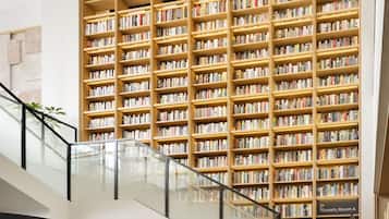 A modern library interior with multiple bookshelves, a glass railing, and a sign indicating '2F 70 seats, Room A'.