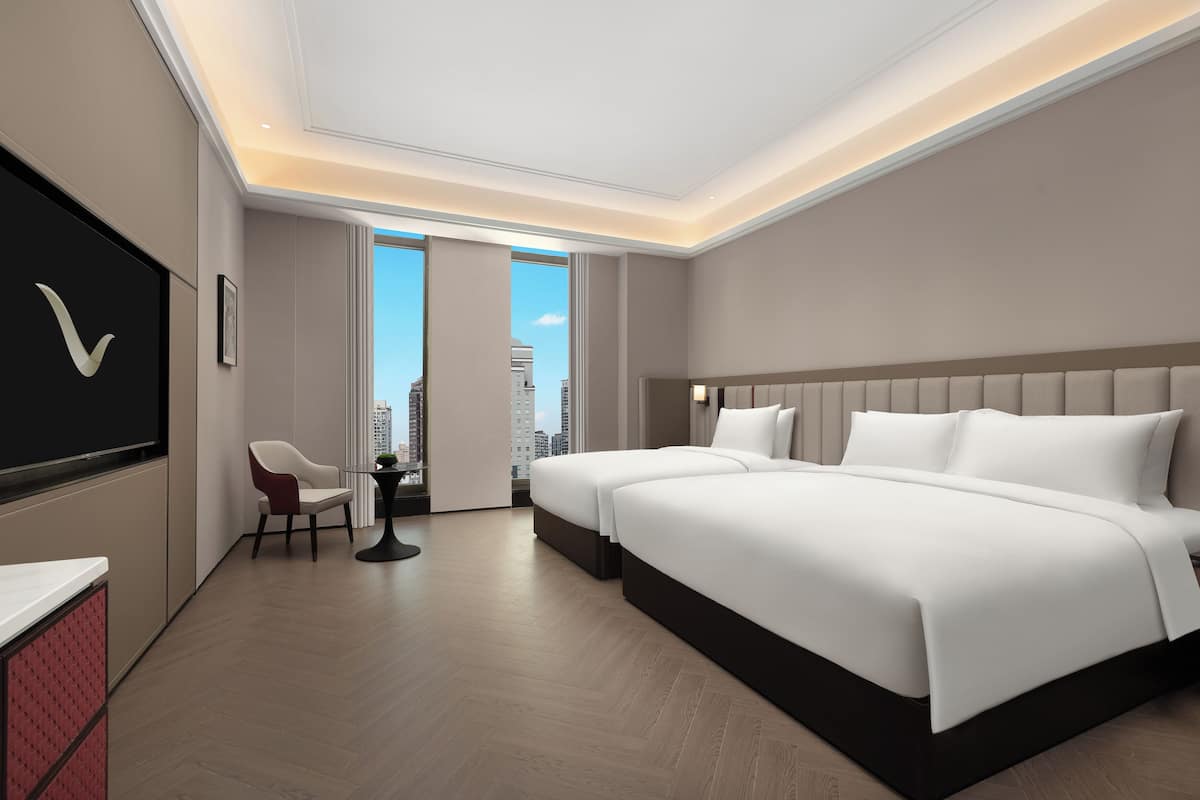 Une chambre d’hôtel moderne, dotée d’un grand lit, d’un bureau et d’une chaise.
