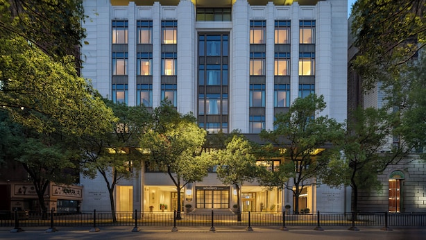 Un edificio moderno con fachada simétrica, ventanas amplias y una entrada central.