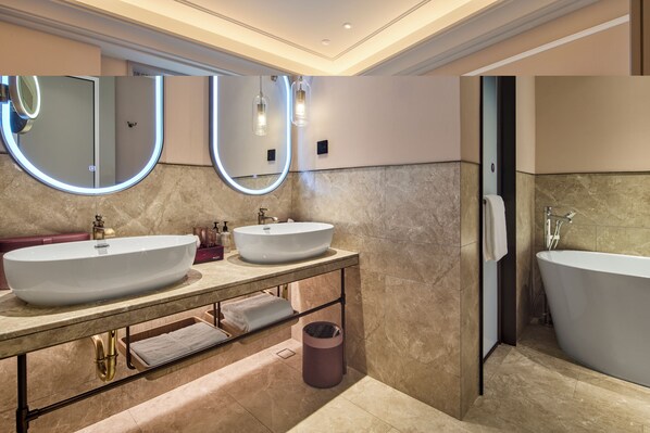 Een moderne badkamer met twee wastafels, een badkuip en een wastafelmeubel met spiegel.