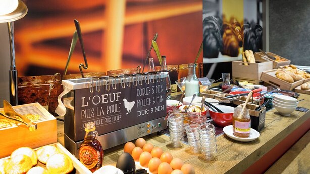 A breakfast buffet with various food items and a sign indicating service times. - Ibis Troyes Centre (Troyes)