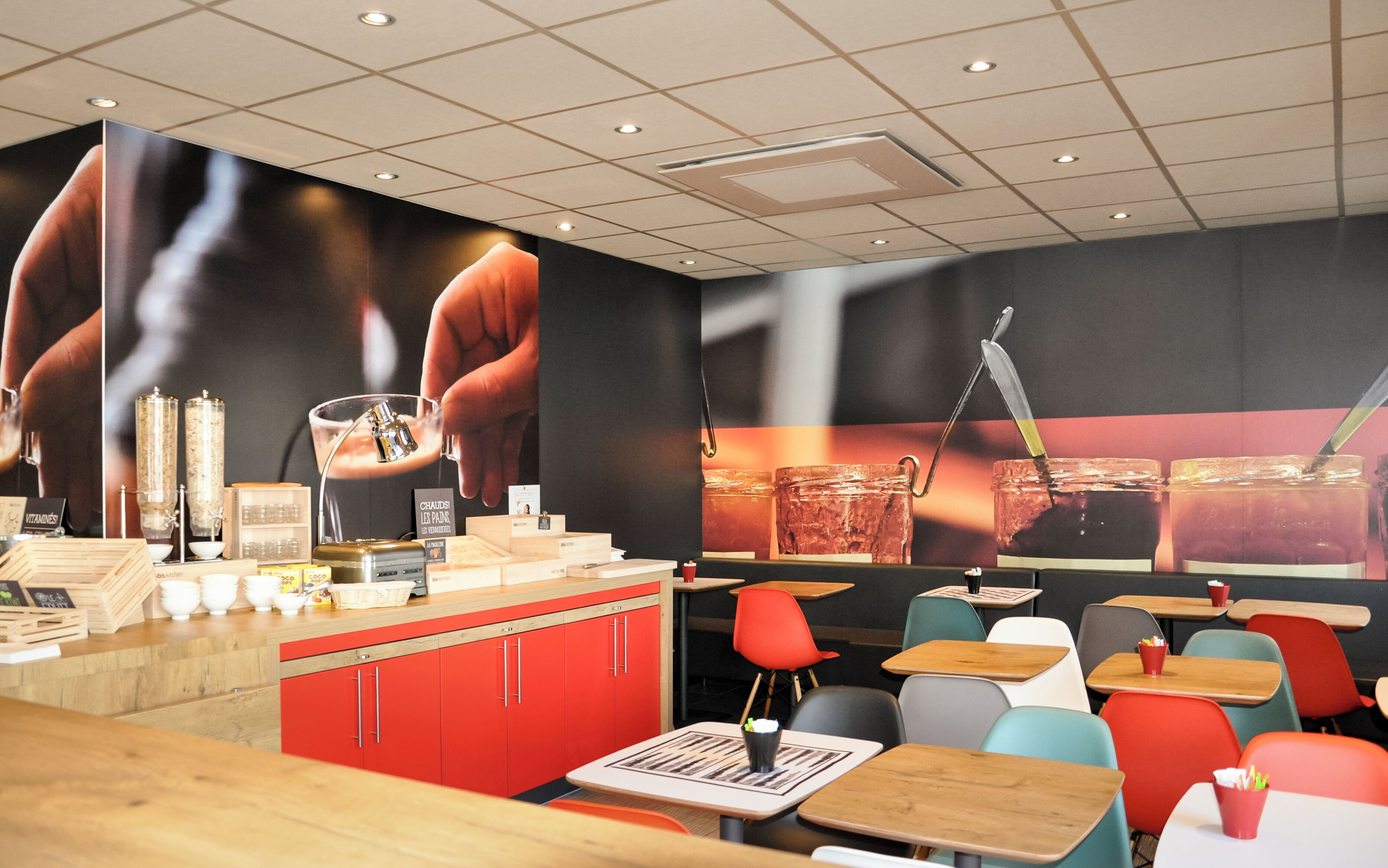 A restaurant interior with a counter, seating area, and a large mural.