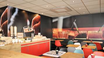 A restaurant interior with a counter, seating area, and a large mural.