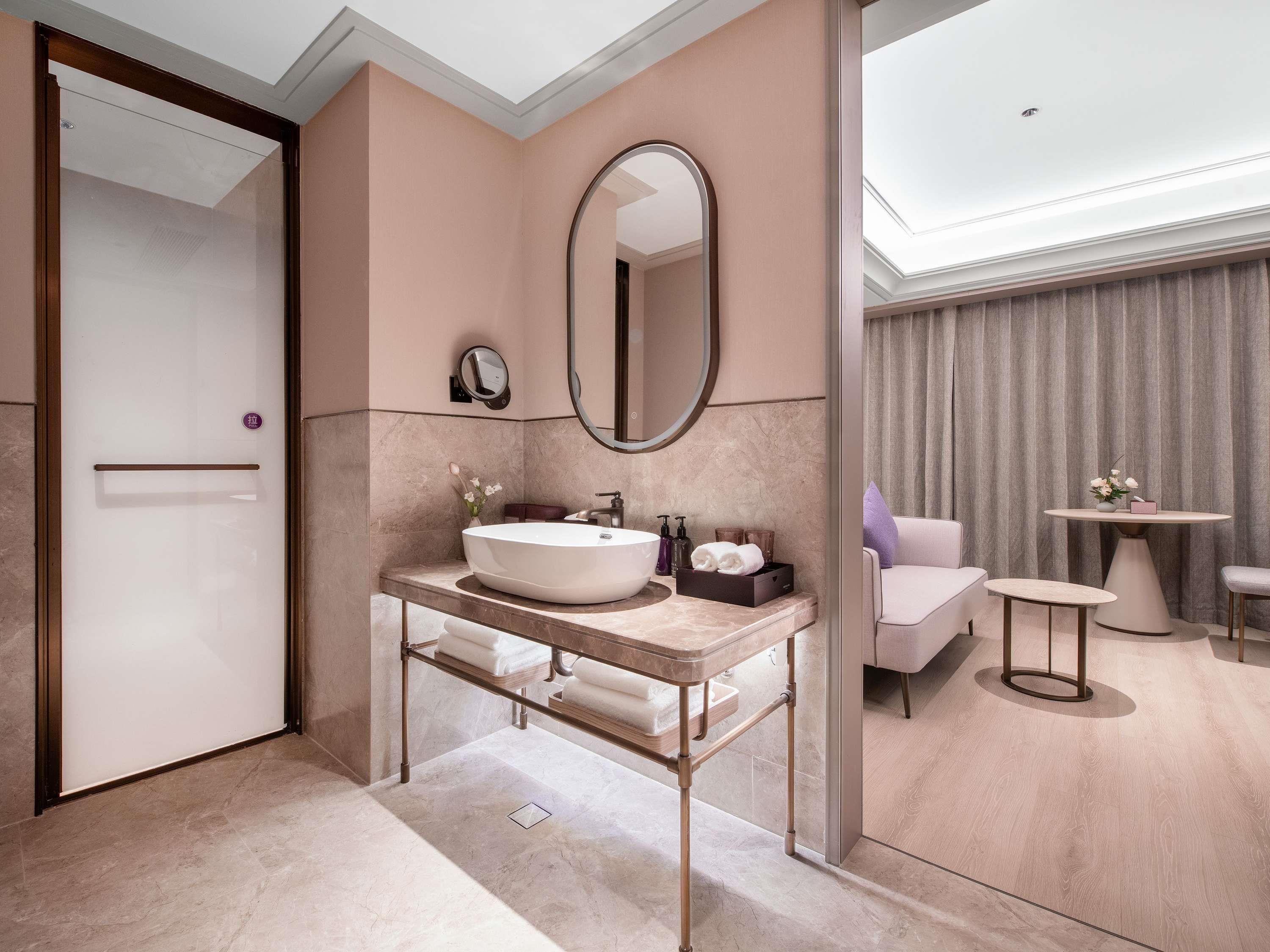 A modern bathroom with a large oval sink, a mirror, and a vanity.