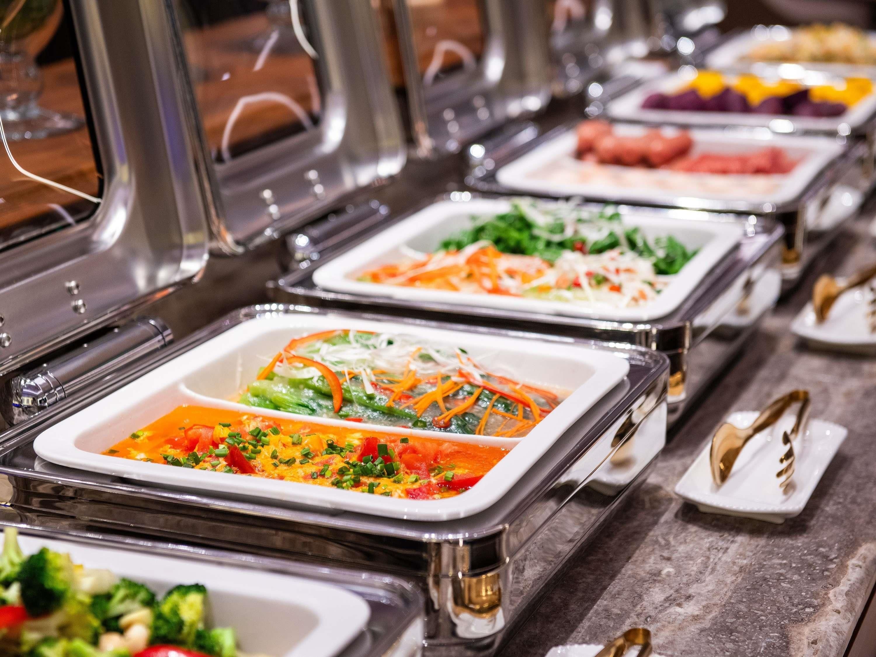 A buffet with various food options, including salads, vegetables, and meats.