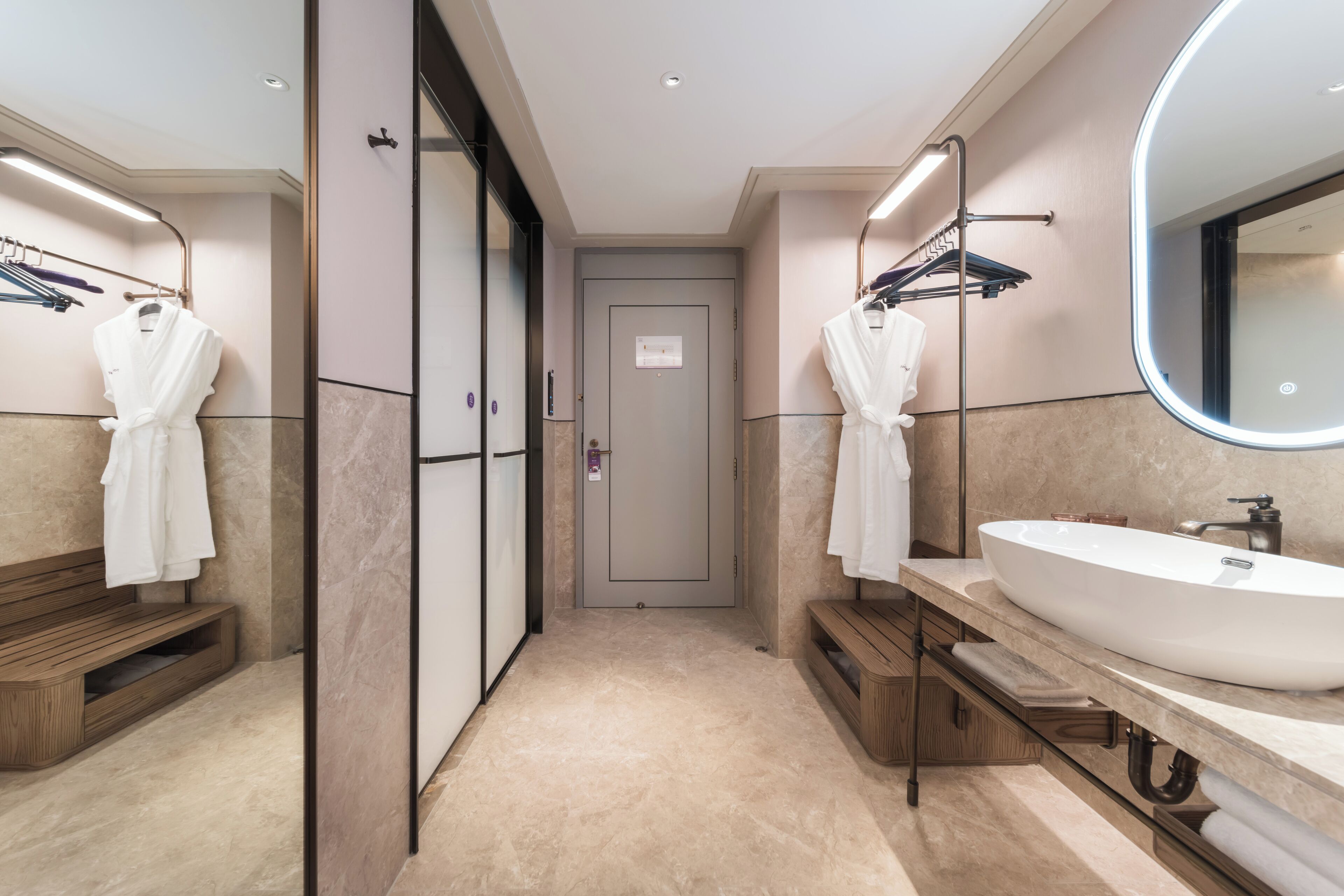 A modern bathroom with a large sink, two towel racks, and a mirror.
