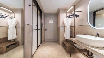 A modern bathroom with a large sink, two towel racks, and a mirror.