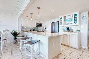 A modern kitchen with white cabinetry, a large island, and stainless steel appliances. - Gulf-view Condo w/ Perks: Suntide III - Unit 205 (South Padre Island)