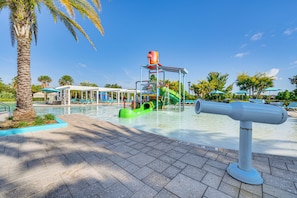Un parc aquatique comprenant un toboggan, une aire de jeux et une zone de piscine.