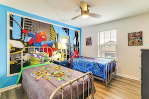Een slaapkamer met twee bedden, een plafondventilator en een raam met jaloezieën.