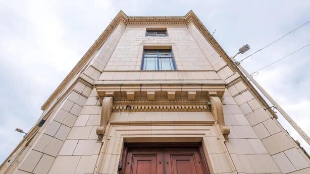 A tall, beige stone building with a central entrance and a window above it. - Bolton City Oasis - Cozy Apartment Rental (Bolton)