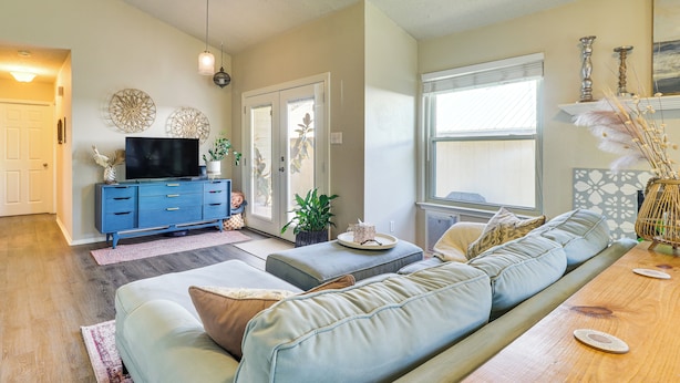 Ein Wohnzimmer mit einem blauen Unterhaltungsschrank, einem großen Sofa und einem Holztisch.