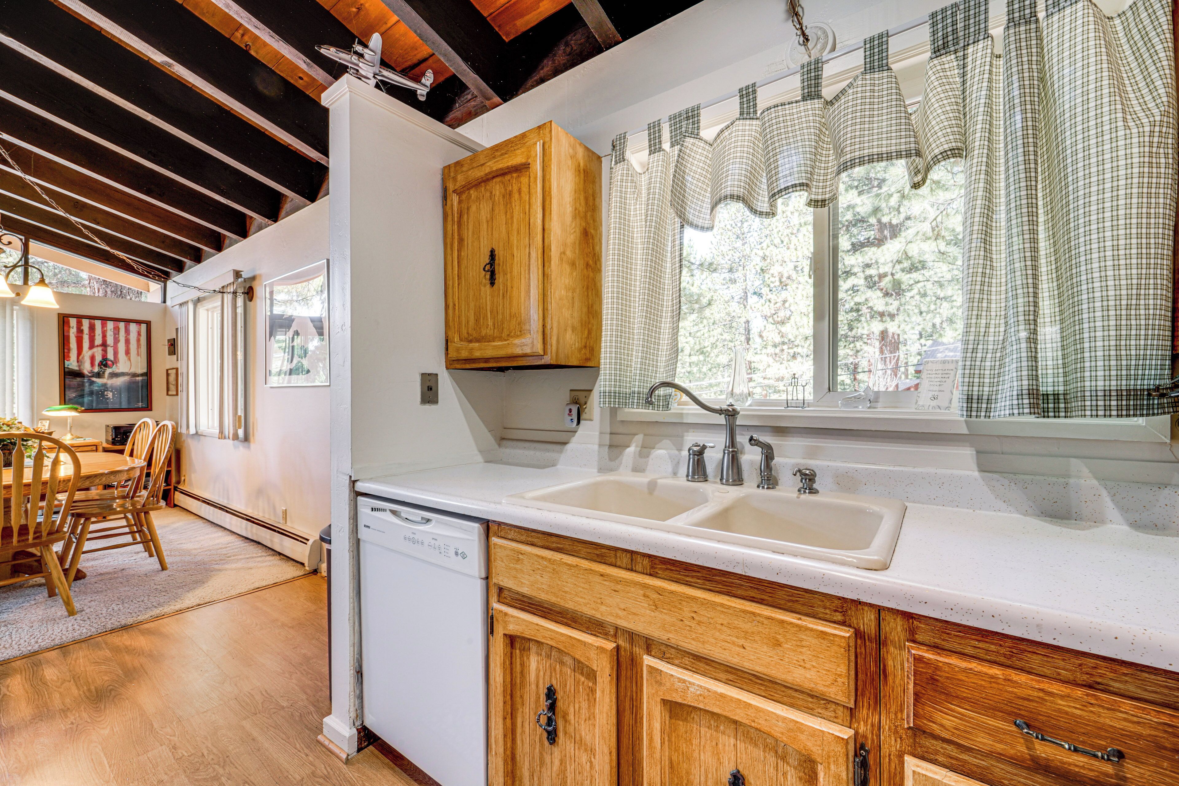 Cocina con armarios de madera, lavavajillas y pileta doble.