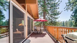 A wooden deck with a glass door leading to a room, a red umbrella, and a kayak. - Walk to Lake Tahoe: Family Retreat w/ Deck! (Incline Village)
