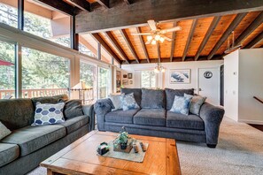A spacious living room with a large gray sofa, a wooden coffee table, and a ceiling fan. - Walk to Lake Tahoe: Family Retreat w/ Deck! (Incline Village)
