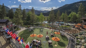 Un complexe hôtelier doté d’une terrasse, d’une piscine et de drapeaux.