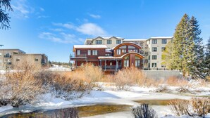 A modern building with a mix of wood and concrete architecture, surrounded by snow and a frozen pond. - 3 Mi to Slopes! Family-friendly Winter Park Escape (Winter Park)