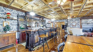 A restaurant with a wooden bar, high ceiling with ornate details, patterned wallpaper, and a classic interior design. - 'the Pickford House' - Luxury Central Coast Stay! (Cambria)